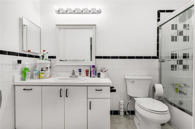 full bathroom featuring vanity, tile patterned flooring, toilet, and tile walls