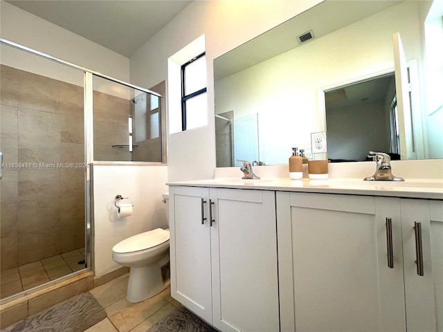 bathroom featuring a shower with door, vanity, tile patterned floors, and toilet