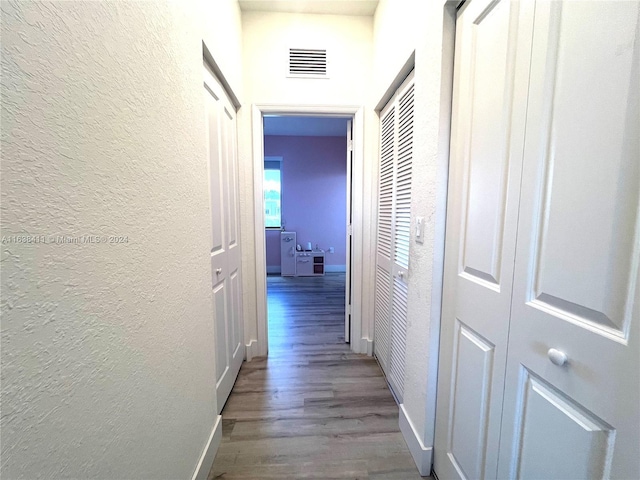 hallway with hardwood / wood-style flooring