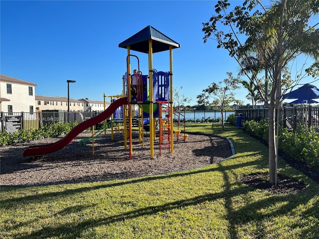 view of jungle gym featuring a water view and a yard