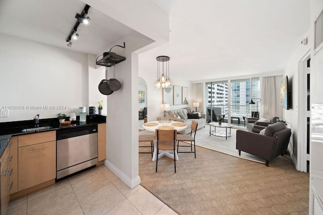 kitchen featuring sink, light tile patterned floors, dishwasher, and rail lighting