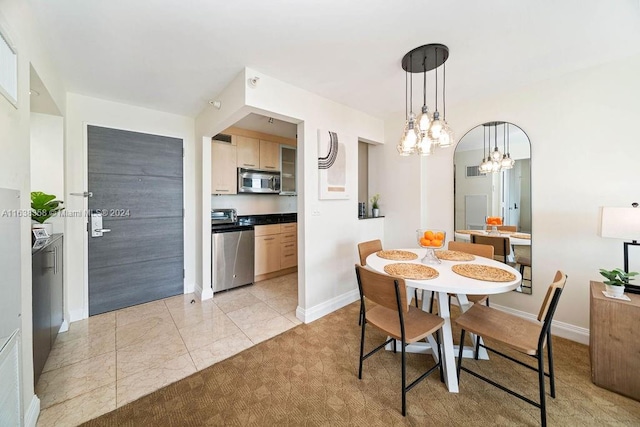 dining space featuring light carpet and an inviting chandelier