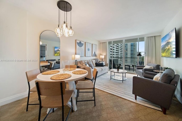 carpeted dining space with an inviting chandelier and floor to ceiling windows