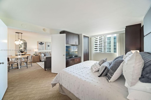 carpeted bedroom featuring a notable chandelier