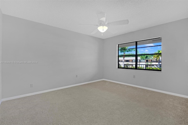 spare room featuring ceiling fan, carpet floors, and a textured ceiling