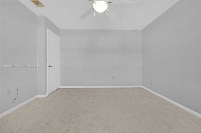 carpeted spare room featuring a textured ceiling and ceiling fan