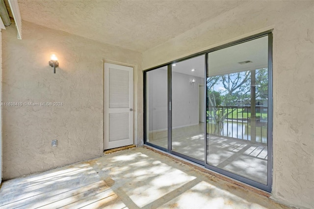 unfurnished room with a water view and concrete flooring