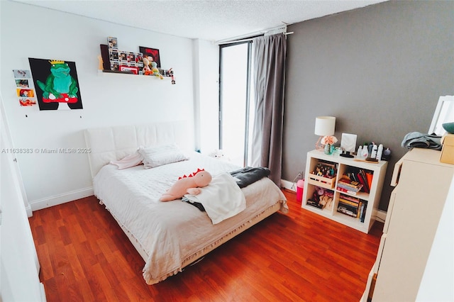 bedroom with a textured ceiling and dark wood-type flooring