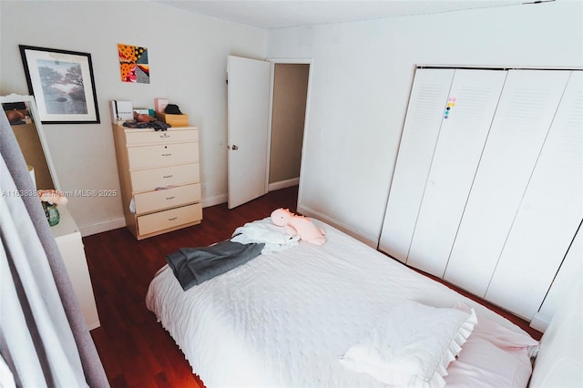 bedroom with dark hardwood / wood-style floors and a closet