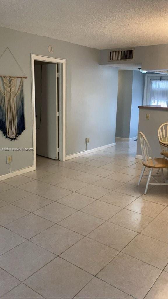 5800 NW 64th Ave Unit 108, Tamarac, FL 33319 - unfurnished room featuring a textured ceiling, baseboards, and light tile patterned flooring