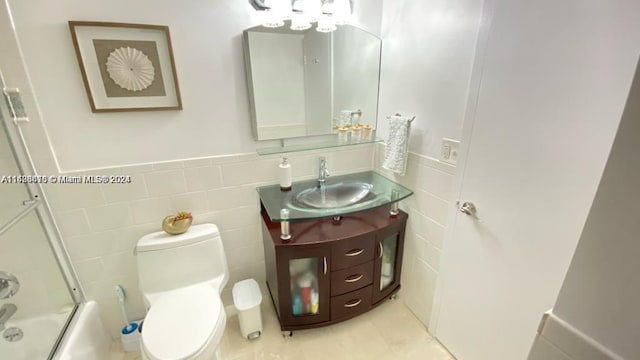 full bathroom with vanity, tile walls, toilet, tile patterned flooring, and backsplash