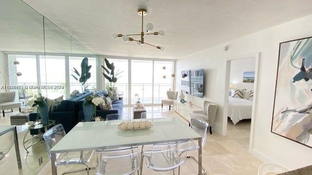 tiled dining room with a chandelier, a textured ceiling, expansive windows, and plenty of natural light