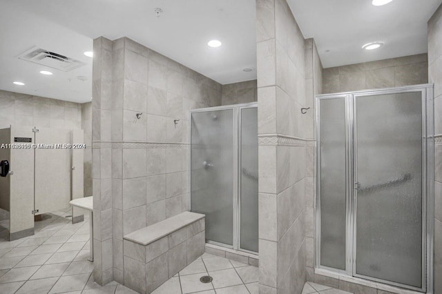 bathroom featuring tile patterned floors, walk in shower, and tile walls