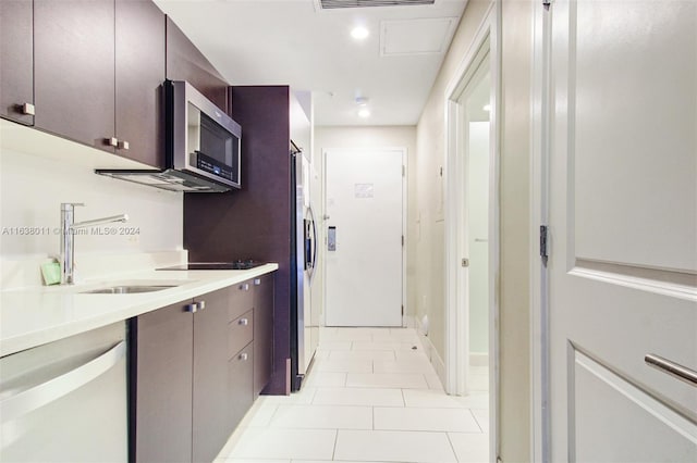 kitchen with sink, light tile patterned floors, and appliances with stainless steel finishes