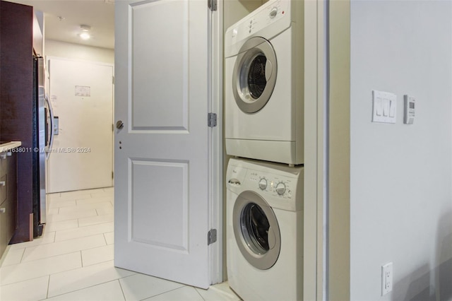 washroom featuring light tile patterned floors and stacked washing maching and dryer