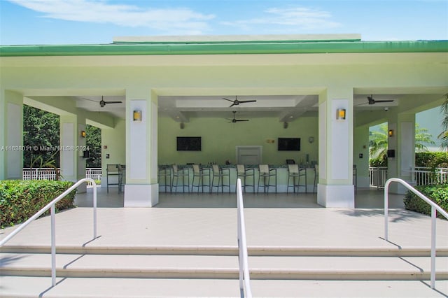 exterior space with ceiling fan and a bar