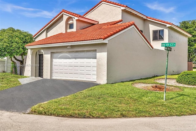 mediterranean / spanish house with a front yard and a garage