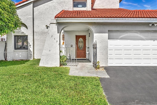 doorway to property with a lawn and a garage