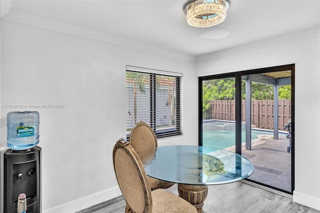 dining space featuring wood-type flooring and crown molding