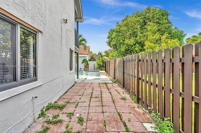 view of patio / terrace with a fenced in pool and pool water feature