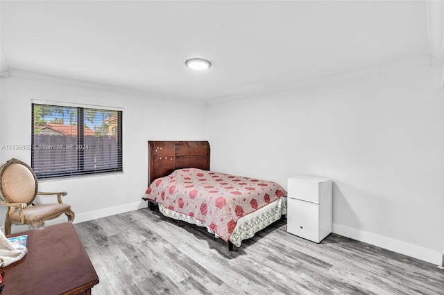 bedroom with light wood-type flooring and ornamental molding