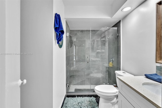 bathroom featuring tile patterned flooring, toilet, vanity, and an enclosed shower