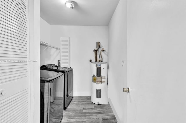 washroom with water heater, wood-type flooring, and separate washer and dryer