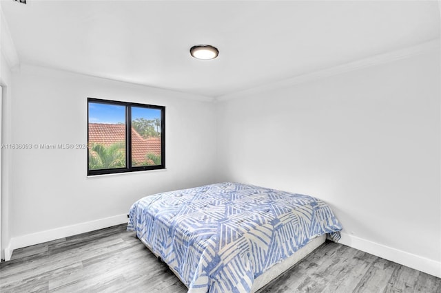 bedroom with crown molding and wood-type flooring