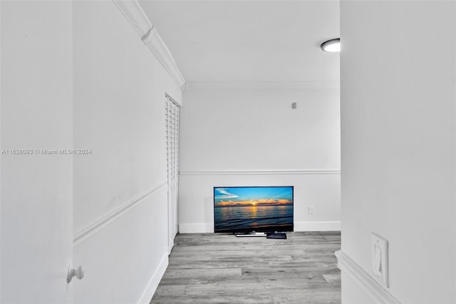 corridor featuring ornamental molding and light hardwood / wood-style floors