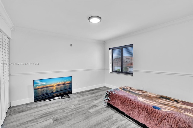 bedroom with ornamental molding and wood-type flooring