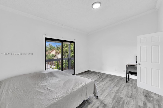 bedroom featuring crown molding, access to exterior, and light hardwood / wood-style floors