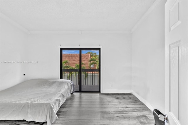 bedroom with access to exterior, hardwood / wood-style flooring, a textured ceiling, and crown molding