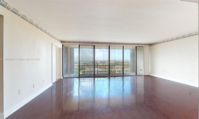 unfurnished room with floor to ceiling windows and dark hardwood / wood-style floors