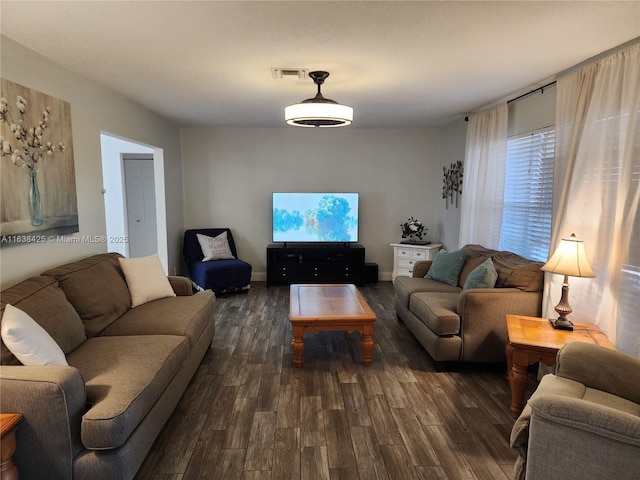 living room featuring baseboards, visible vents, and dark wood-type flooring