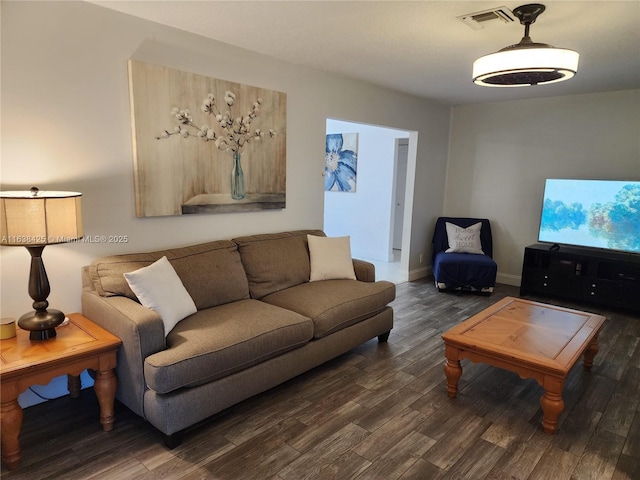 living room featuring baseboards, visible vents, and wood finished floors