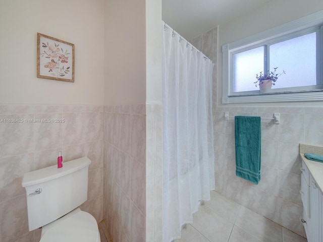 bathroom featuring curtained shower, toilet, vanity, tile walls, and tile patterned floors