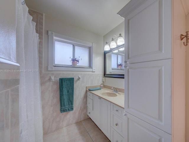 bathroom with a wainscoted wall, a shower with curtain, tile patterned floors, vanity, and tile walls