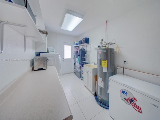 interior space with light tile patterned floors, laundry area, and electric water heater