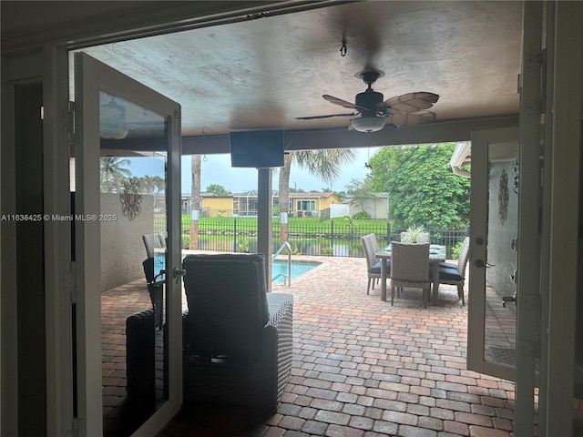 view of patio with ceiling fan, outdoor dining area, fence, and a fenced in pool