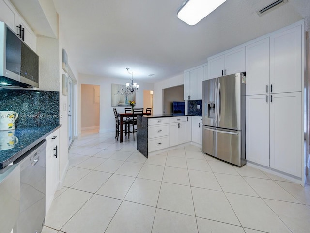 kitchen with a peninsula, appliances with stainless steel finishes, light tile patterned flooring, and visible vents