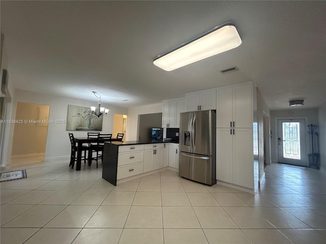 kitchen featuring light tile patterned floors, a peninsula, stainless steel refrigerator with ice dispenser, and visible vents