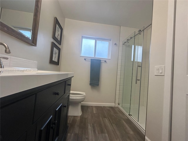 full bathroom featuring vanity, wood finished floors, toilet, and a shower stall