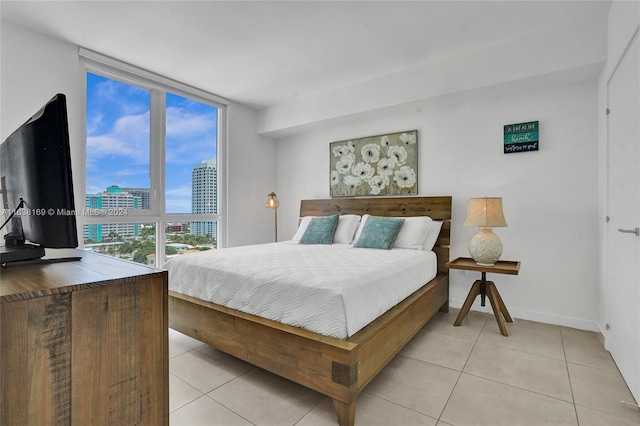 tiled bedroom featuring a wall of windows