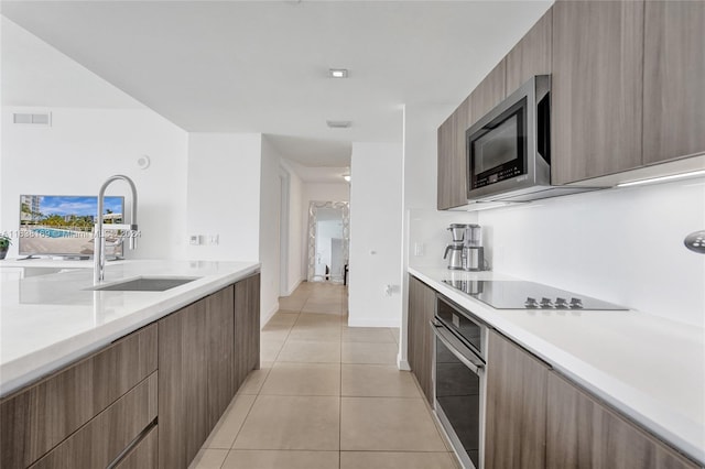 kitchen with light tile patterned floors, sink, and stainless steel appliances