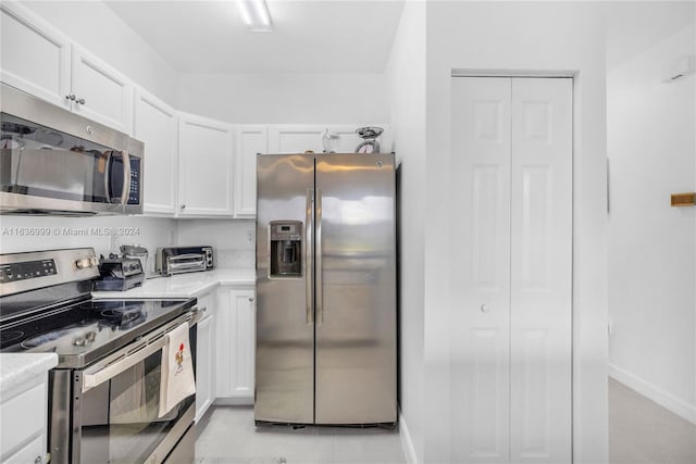 kitchen with white cabinetry, light tile patterned floors, light stone counters, and stainless steel appliances