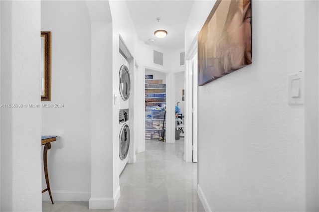 hallway featuring tile patterned floors and stacked washer / drying machine