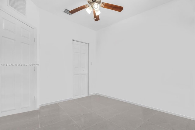 tiled empty room featuring ceiling fan