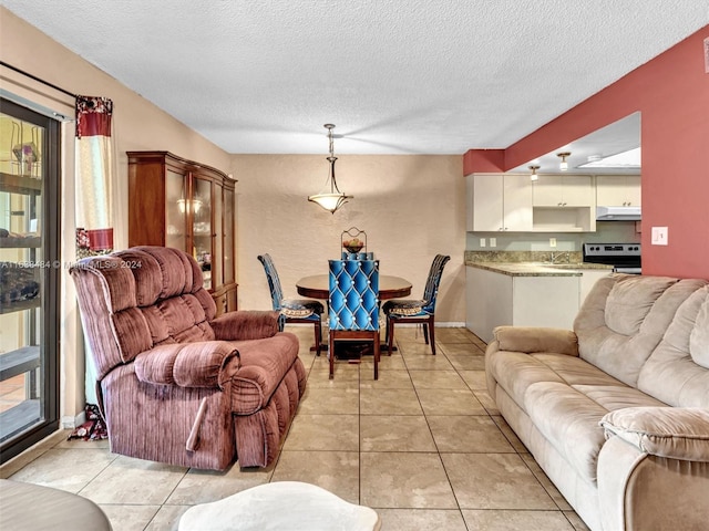 living room featuring light tile patterned floors, a healthy amount of sunlight, and a textured ceiling