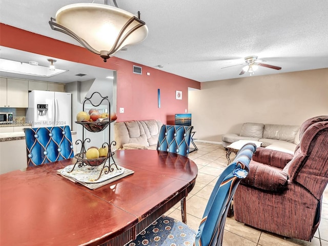 tiled dining room featuring ceiling fan and a textured ceiling