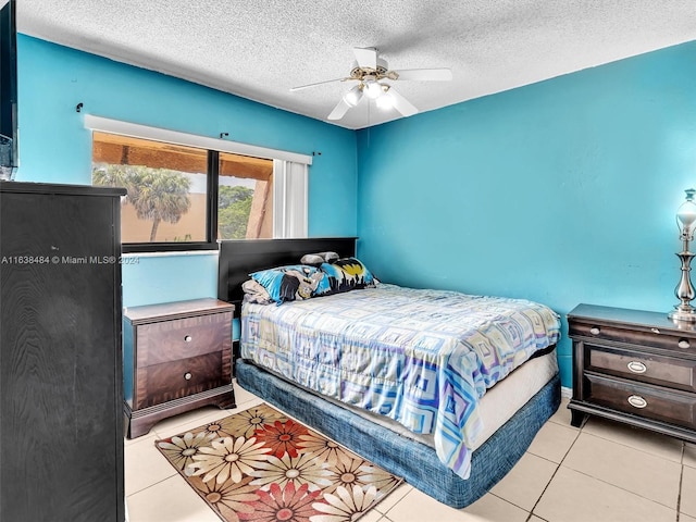 tiled bedroom featuring a textured ceiling and ceiling fan